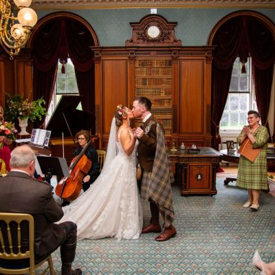 Couple's first kiss with celebrant onlooking